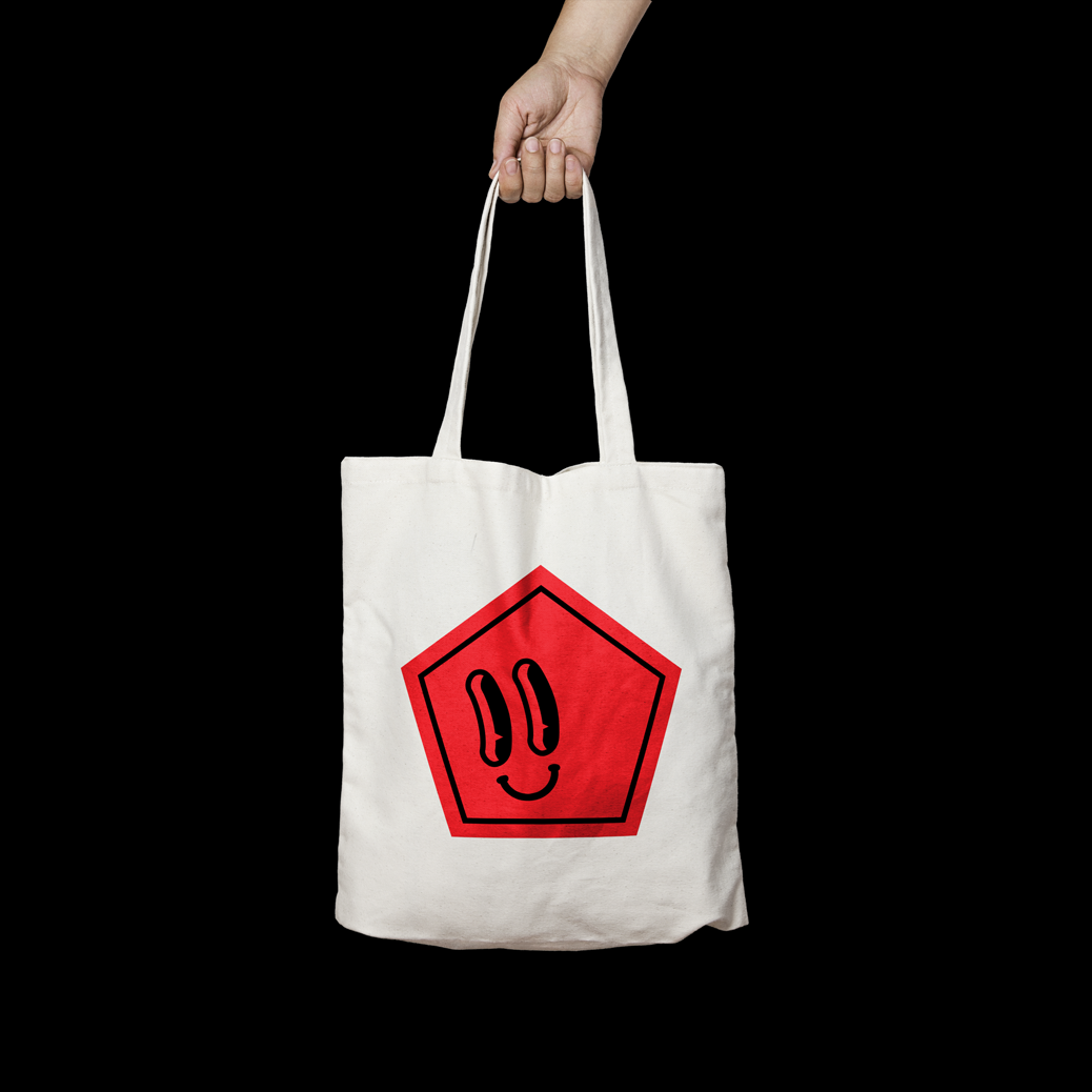 Mockup of white totabag with a printed red pentagon with a face.